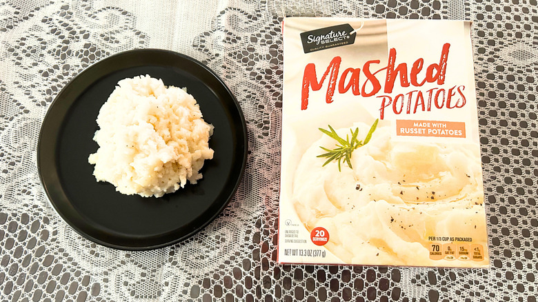 A black plate of mashed potatoes