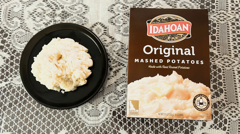 A plate of mashed potatoes next to a box of Idahoan Original Mashed Potatoes