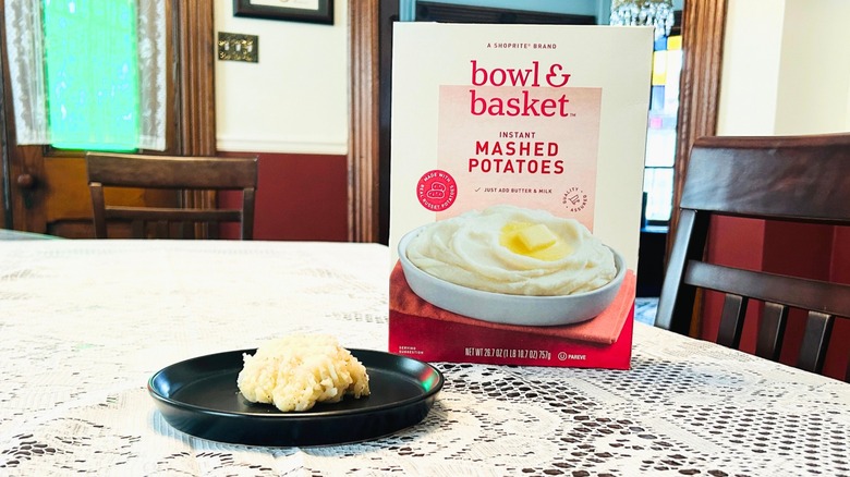 Plate of mashed potatoes next to a box of Bowl and Basket Instant Mashed Potatoes