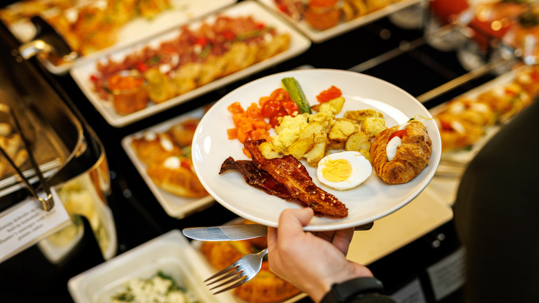 Person holding plate with food at a buffet