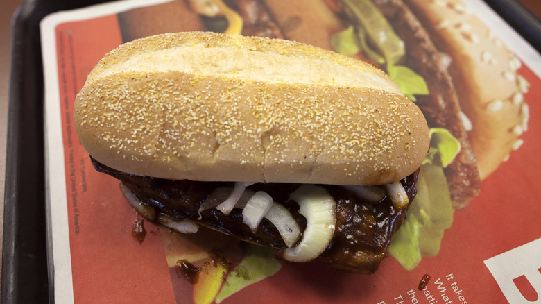 View of a McRib, showing pork patty shape and slivered onions