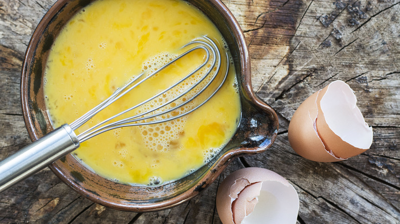Eggs with whisk and eggshells