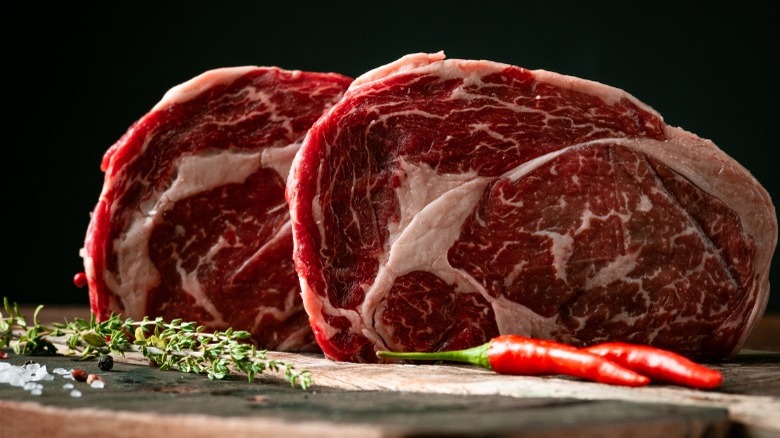 Two raw ribeye steaks