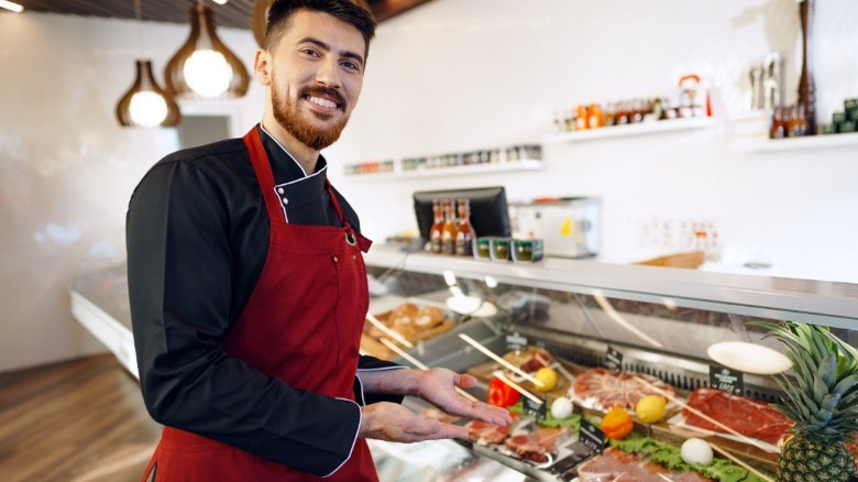 Butcher in front of meat display