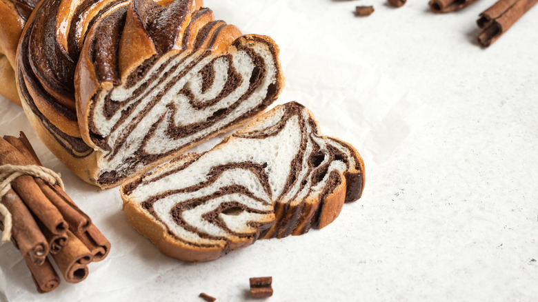 Cinnamon babka sliced next to cinnamon