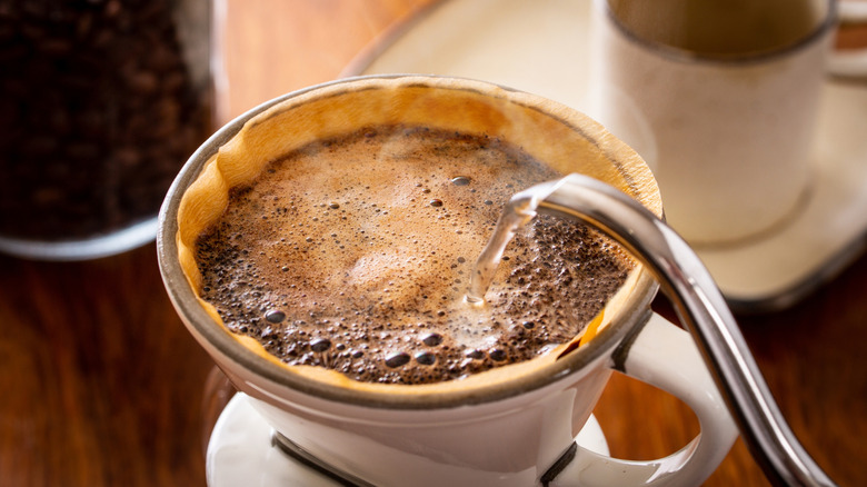 Water pouring into coffee grinds