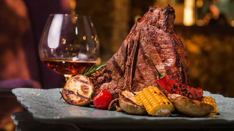steak with vegetables and whiskey glass