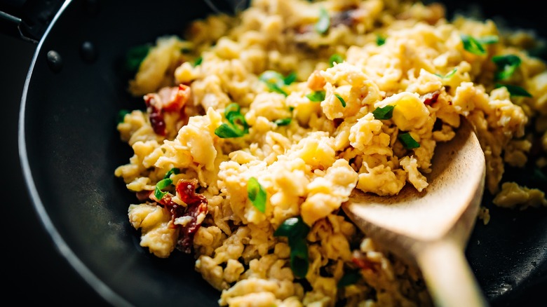 closeup of scrambled eggs wooden spoon