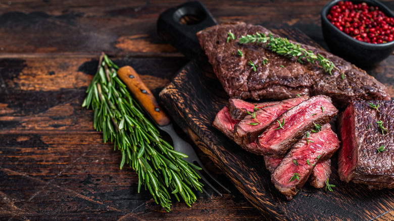 partially sliced steak with rosemary