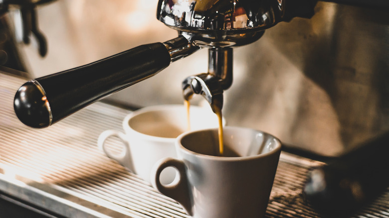 An espresso machine brewing shots on two cups 