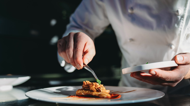 Professional chef garnishing food