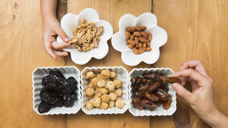 Parent and child holding nuts and dates