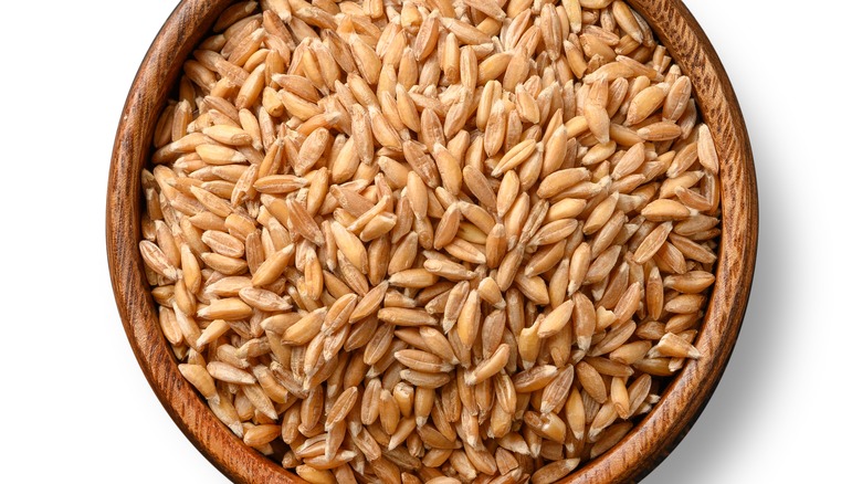 Farro in wooden bowl white background