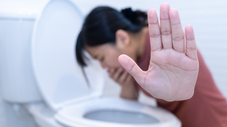 sick woman over toilet