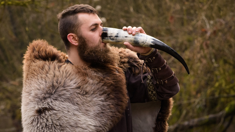 man in viking attire drinking from drinking horn