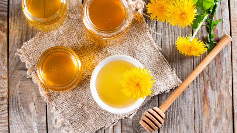honey, mead, and dandelions on a wooden table