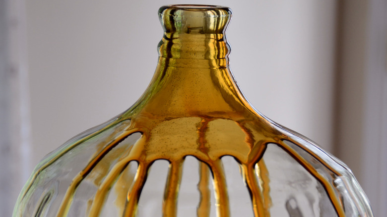 large jar with honey dripping on inside