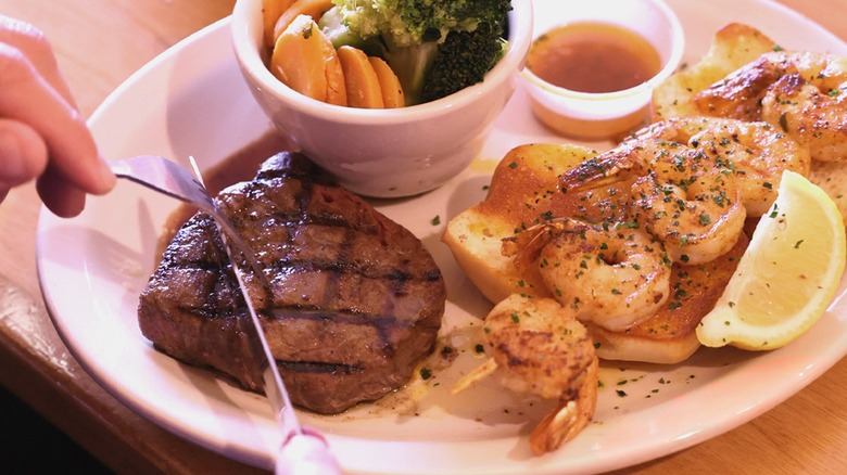Person cutting into a steak at Texas Roadhouse