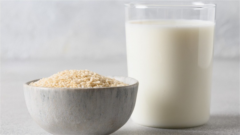 bowl of sesame seeds next to glass of sesame milk