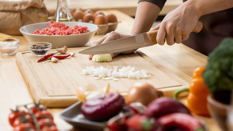 Person chopping onion on cutting board