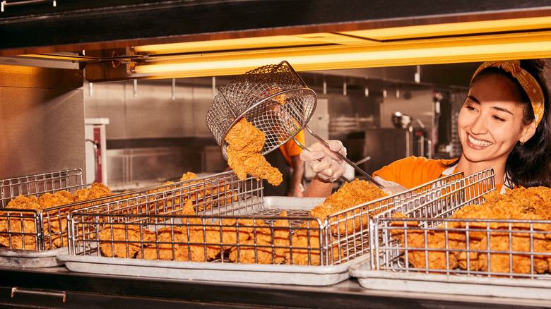 Popeyes employee serving up freshly-fried chicken