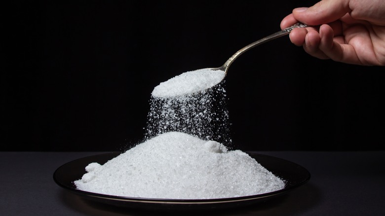 spoon dropping salt onto pile