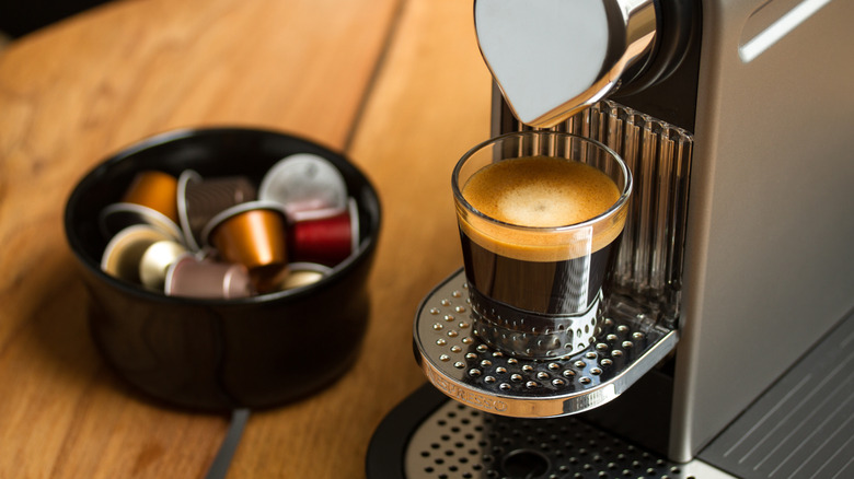 Freshly brewed espresso in a glass on a Nespresso coffe machine.