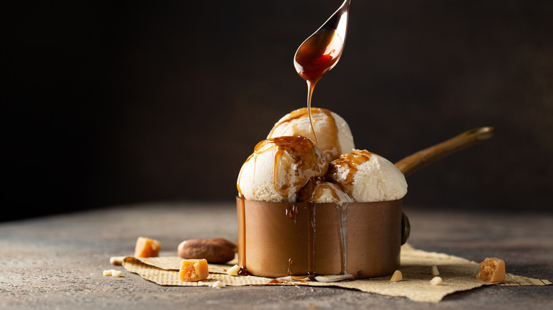 drizzling caramel sauce over saucepan with vanilla icecream