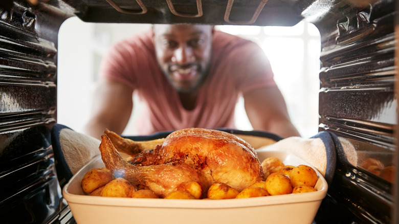 man roasting a chicken