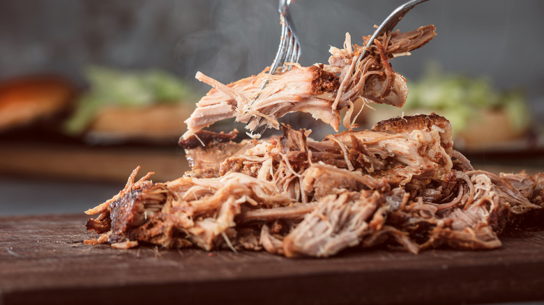 two forks pulling apart pork