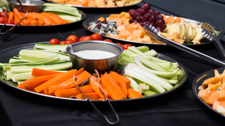 Party platter with veggies, fruit, and cheese on black table