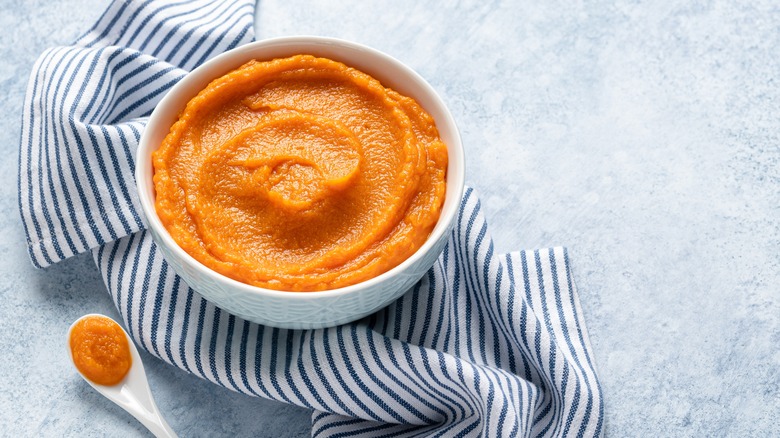 Bowl of pumpkin puree on striped towel