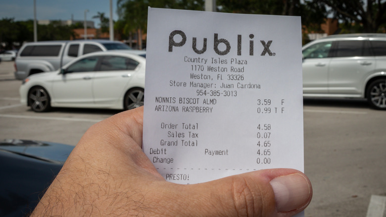 Hand holding Publix receipt