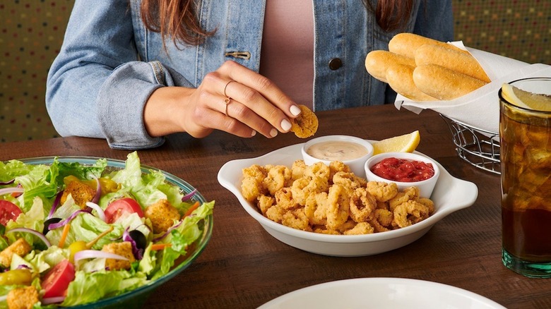 woman dipping Olive Garden fried calamari appetizer