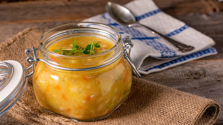 swing-top glass jar of homemade soup on placemat on table