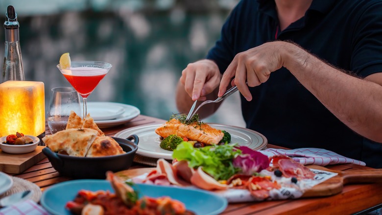 Cutting salmon with a cocktail on the side