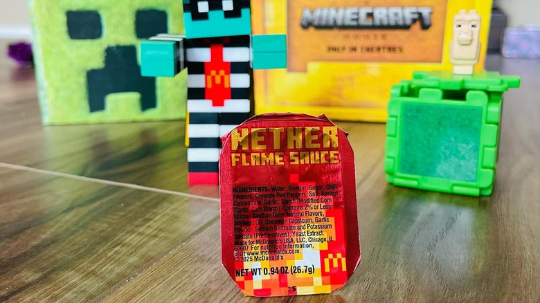 A packet of McDonald's Nether Flame Sauce with Minecraft figurines in the background
