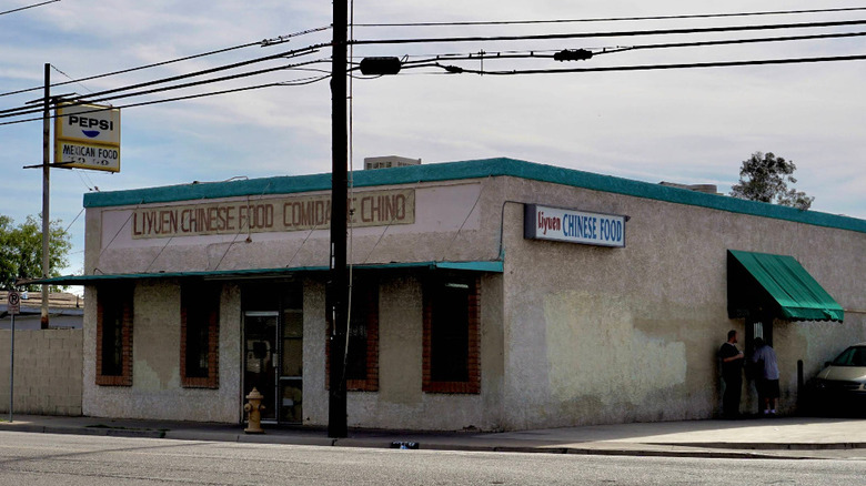 The exterior of Liyuen Chinese Food restaurant in Phoenix, Arizona, with simple signage and a walk-up window on the parking lot side.