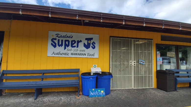 A sign on the front of the bright yellow Kaaloa's Super Js restaurant in Captain Cook, Hawaii advertises its Authentic Hawaiian Food.
