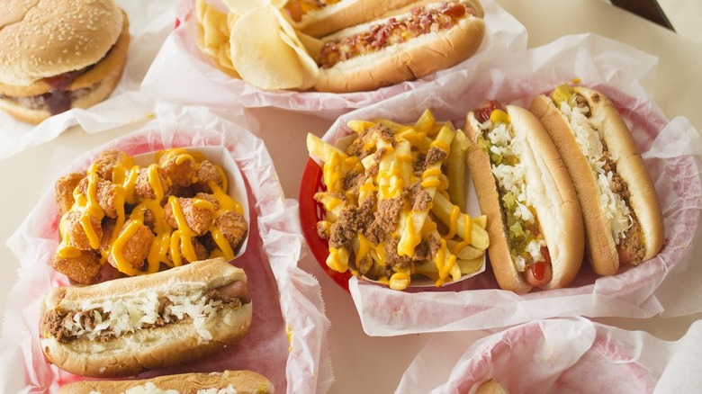 A variety of hotdogs, tater tots, and fries from County Fare restaurant in Somerset, Massachusetts sport toppings like chili, cheese, onions, relish, bacon and mustard.