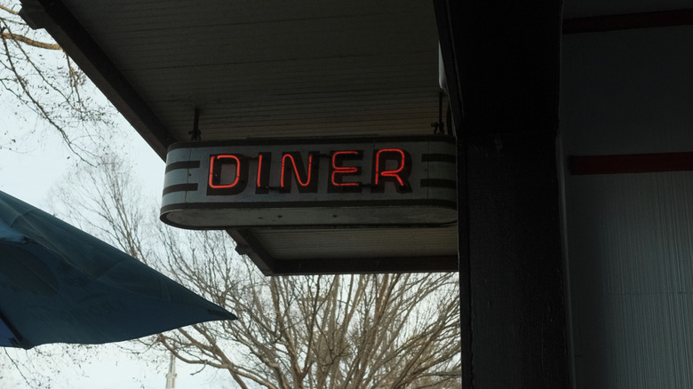 An old-style neon diner sign outside a local restaurant.