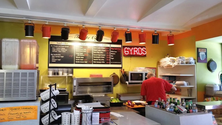 Inside the Trieste Cafe, with bright yellow walls and a neon sign saying "gyros" in Minneapolis, Minnesota.