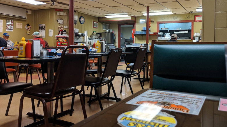 Inside of Betty's Cafe in St. Joseph, Missouri is a cozy hole-in-the-wall diner vibe, with wood paneled walls and classic metal napkin holders on booth-style tables.