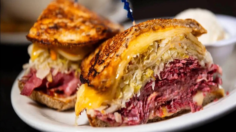 A photo of a Reuben sandwich from Fisher's Deli in Henderson, Nevada, piled high with beef, melted cheese, and sauerkraut on perfectly toasted golden bread.