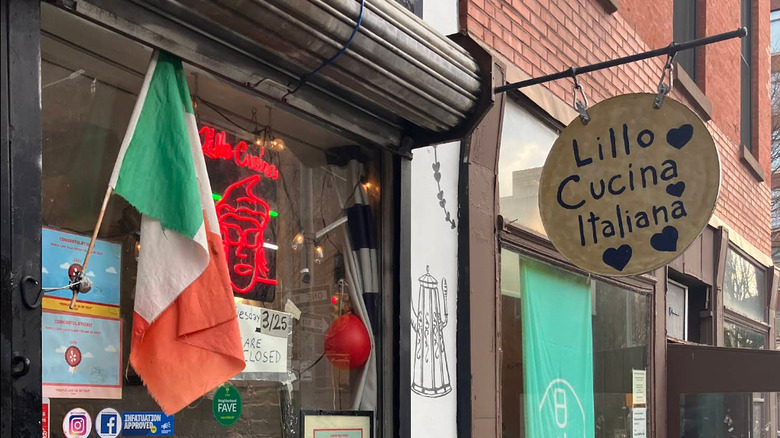 An Italian flag flies at the small New York City storefront of Lillo Cucina Italiana with its round, hand-painted sign.