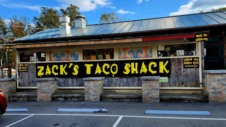Tie-dye patterning and wacky lettering covers the tin-roofed cottage building of Zack's Taco Shack in Tannersville, Pennsylvania.