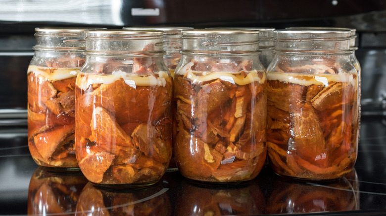 Sealed mason jars containing sliced ham in pork broth