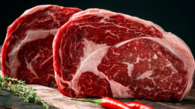 uncooked ribeye steaks standing tall