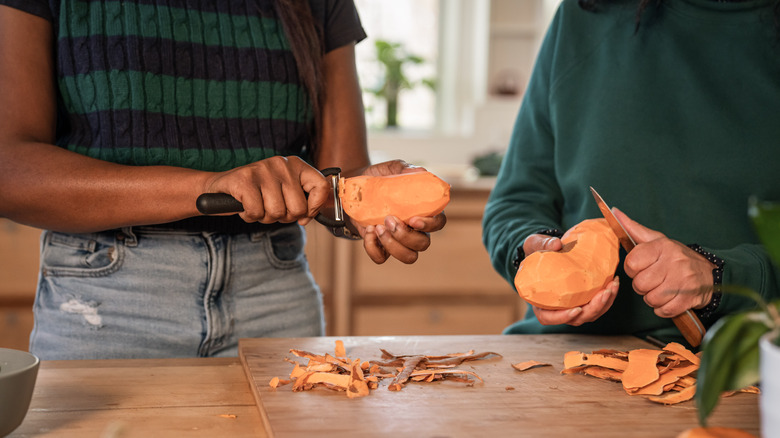 Women peeling sweet potatoes before freezing them