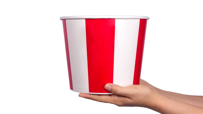 Hands holding striped chicken bucket 